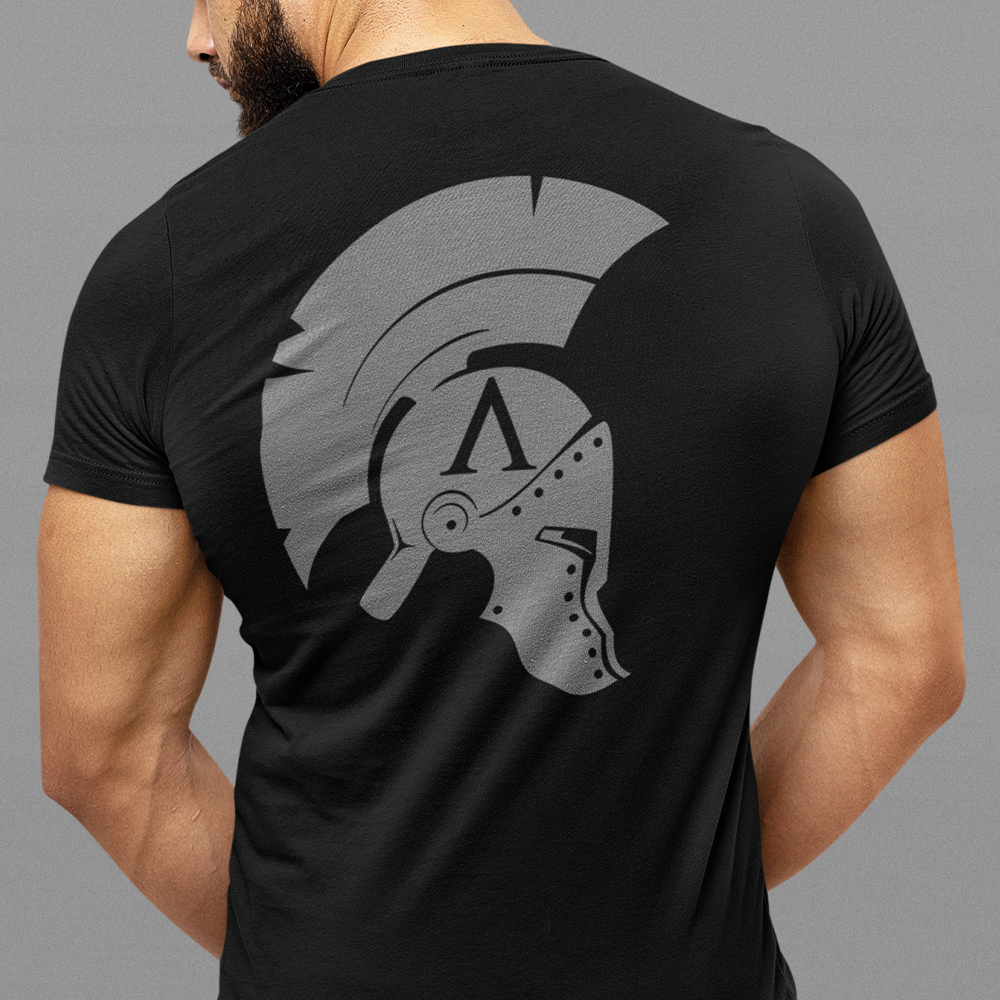 Back view of man wearing Black short sleeve unisex fit original cotton T-Shirt by Achilles Tactical Clothing Brand printed with Icon branded design across back