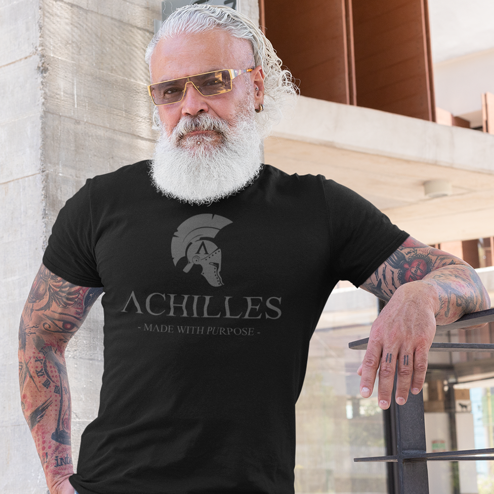 Front view of a man wearing a black cotton T-shirt by Achilles Tactical Clothing Brand with grey Achilles Signature logo screen printed across the front