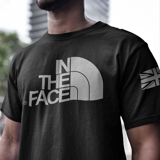 Close up of front of Man wearing Black short sleeve unisex fit cotton T-Shirt by Achilles Tactical Clothing Brand printed with In The Face logo design across the Front